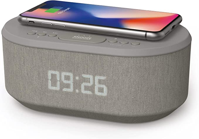 gray alarm clock with phone charging on top